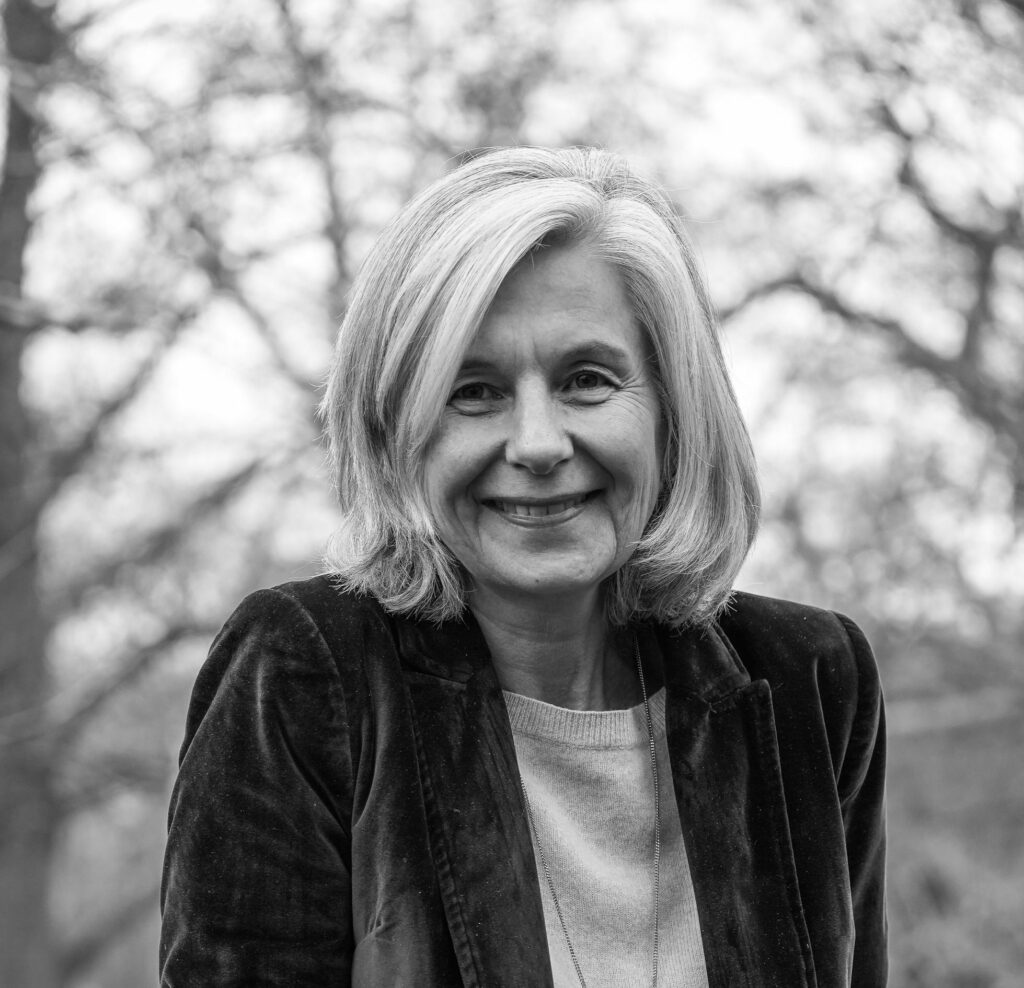 Portait en noir et blanc de Catherine Chavigny, arborant un sourire franc