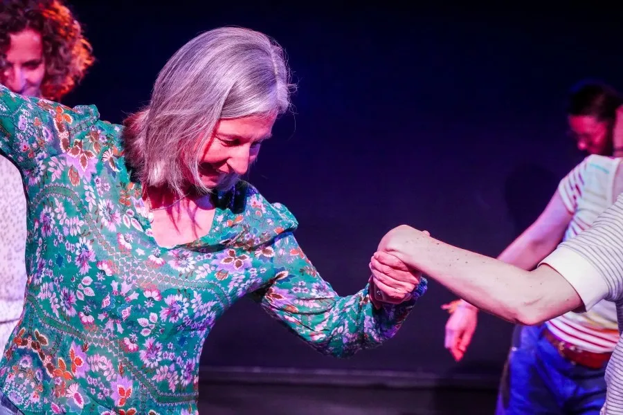 Réussir sa transition professionnelle : photo d'un atelier de coaching où l'on voit des personnes en mouvement, l'une tient la main de l'autre